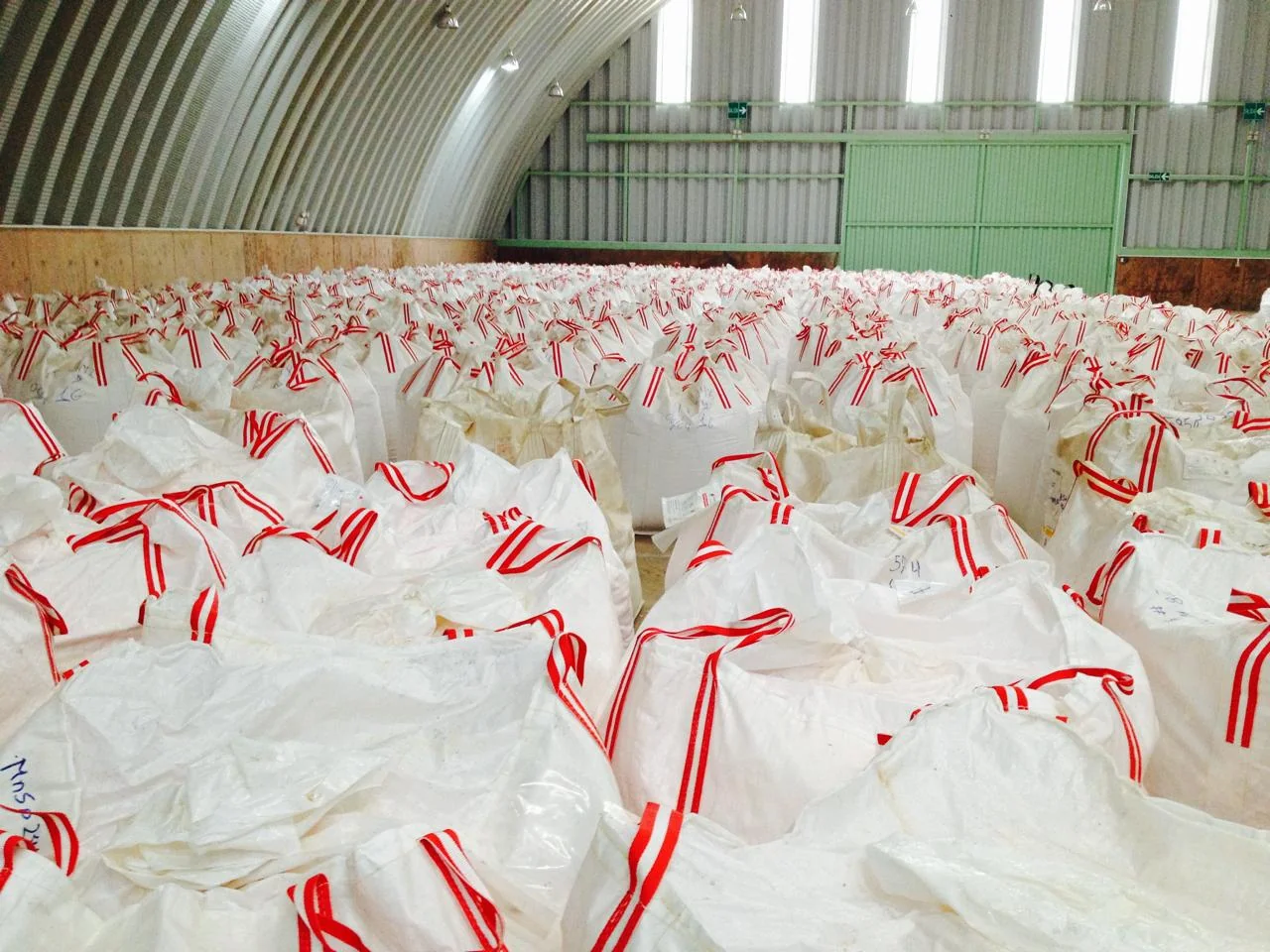 Big Bags NEGASAC llenos con asas rojas y blancas en almacén